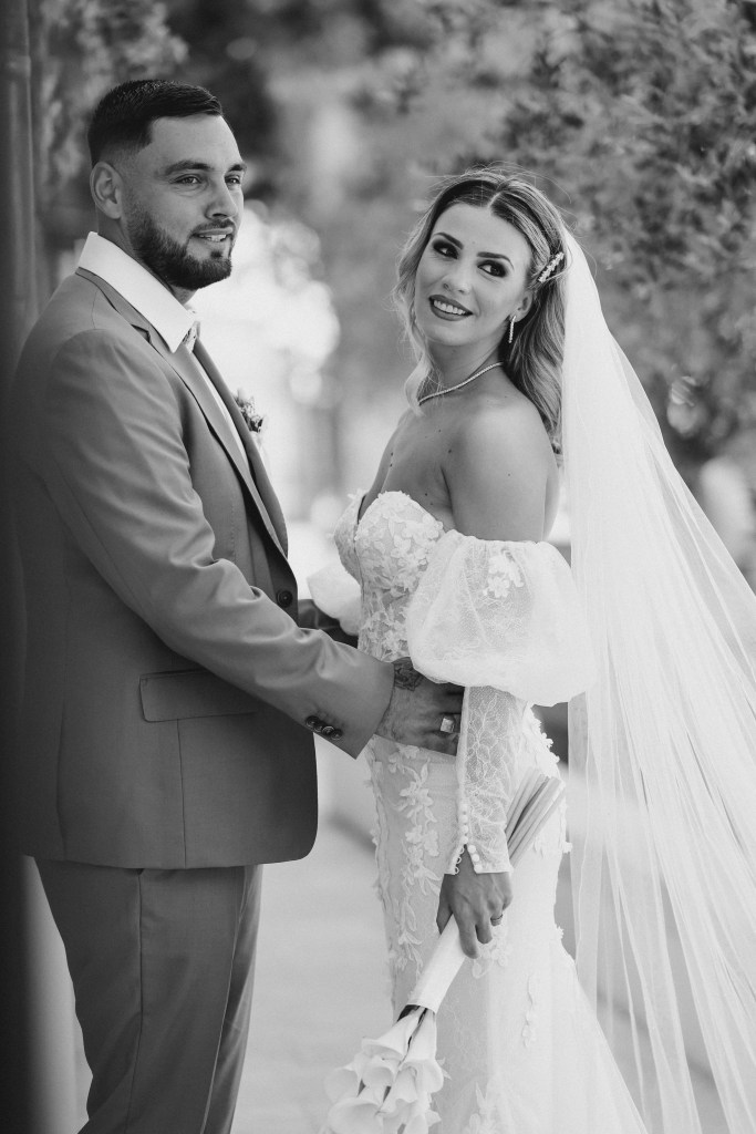 Portrait noir et blanc des mariés, la mariée se retourne en souriant